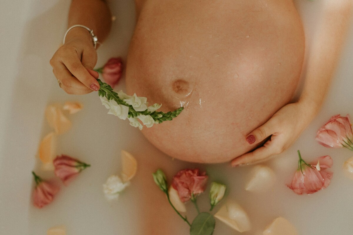 woman laying in tub with flowers